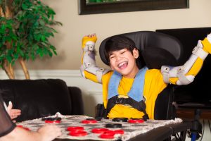 child in wheelchair happily playing a game 